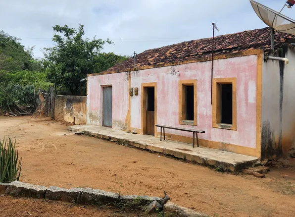 Casa de uma comunidade rural da Caatinga, com terreiro de chão batido e vegetação ao redor
